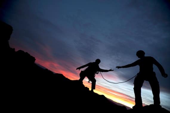 iStock_000010526083Small.jpg A Climber Reaching Out to Help His Partner - Photo courtesy of ©iStockphoto.com/DOUGBERRY, Image #10526083