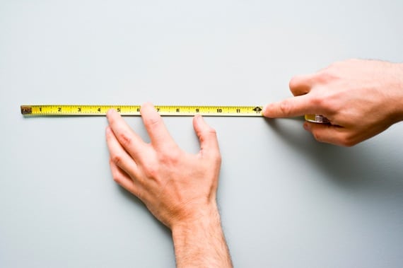 Men's Hands Holding a Measuring Tape Against a Wall - Photo courtesy of &copy;iStockphoto.com/michellegibson, Image #14720530